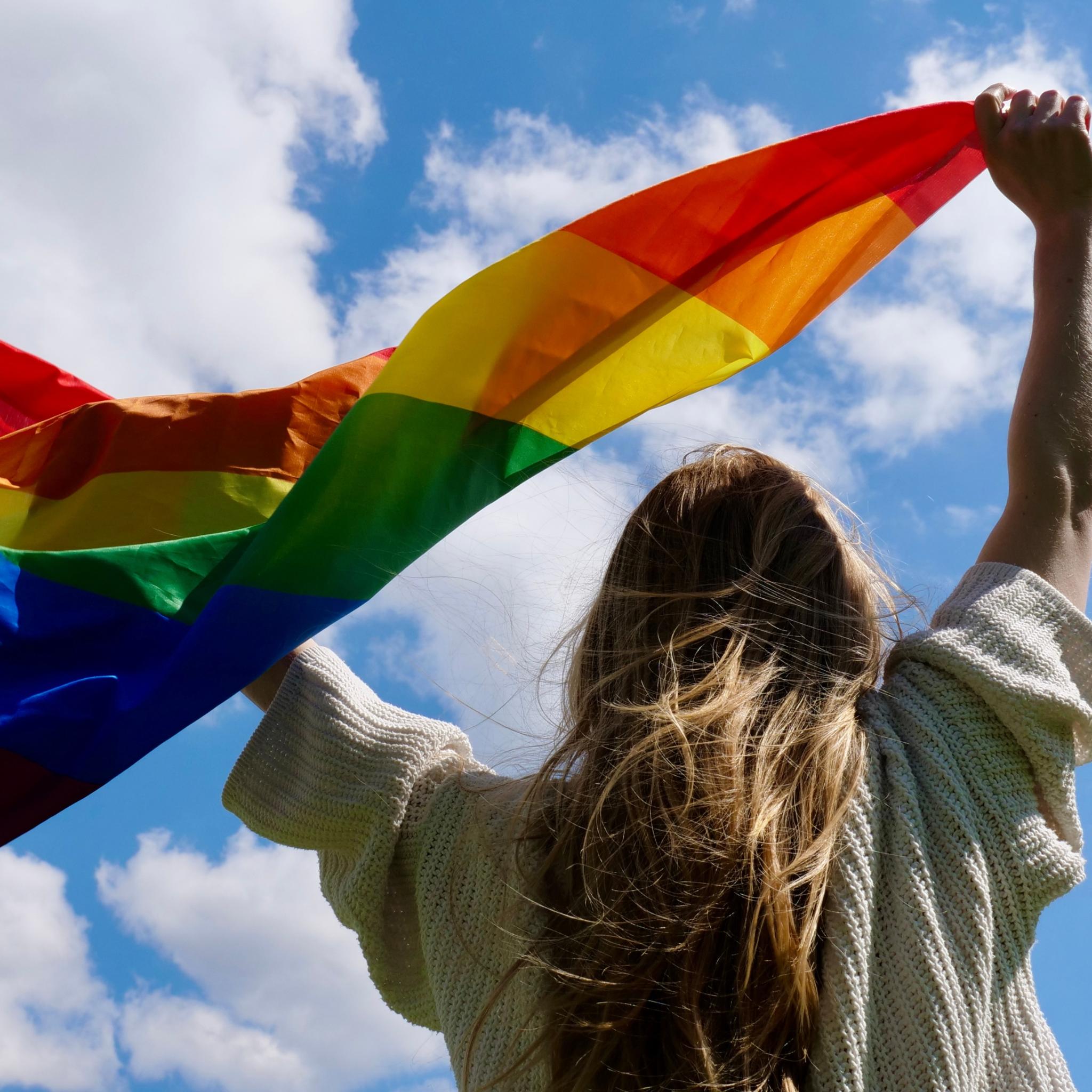 Mensch mit Regenbogenfahne